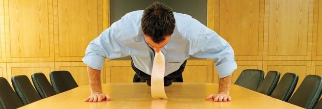 business-man-doing-pushups-on-conference-table