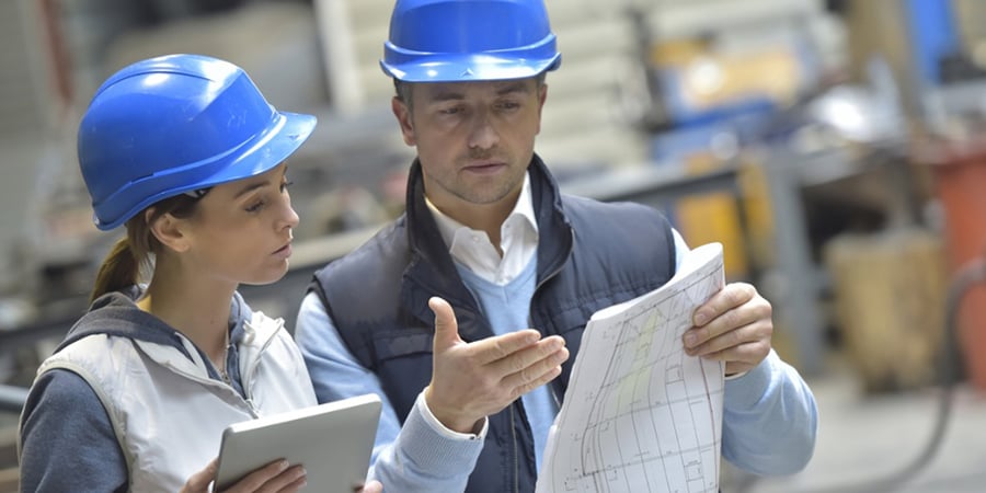 Engineers in mechanical factory reading instructions