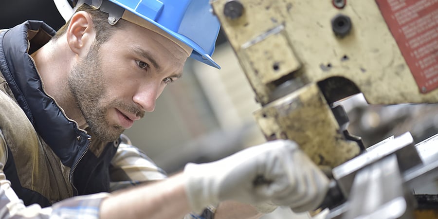 Industrial worker working on machine in factory