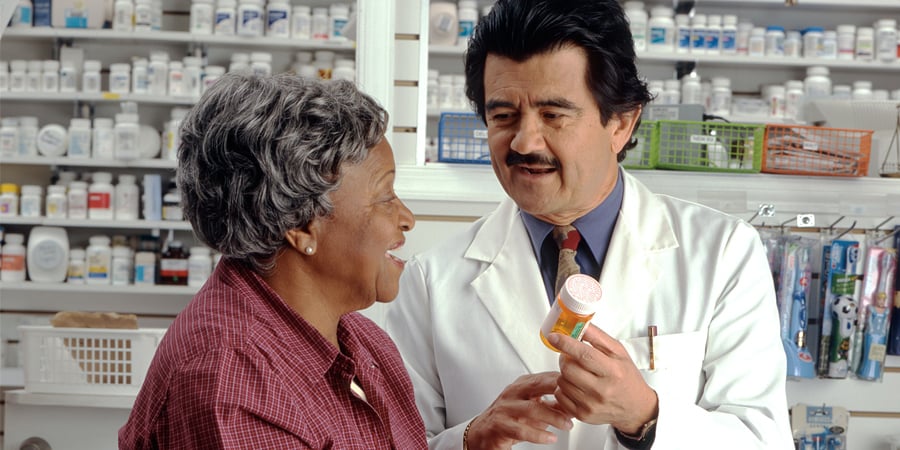 Pharmacist talks about medication with pharmacy patient