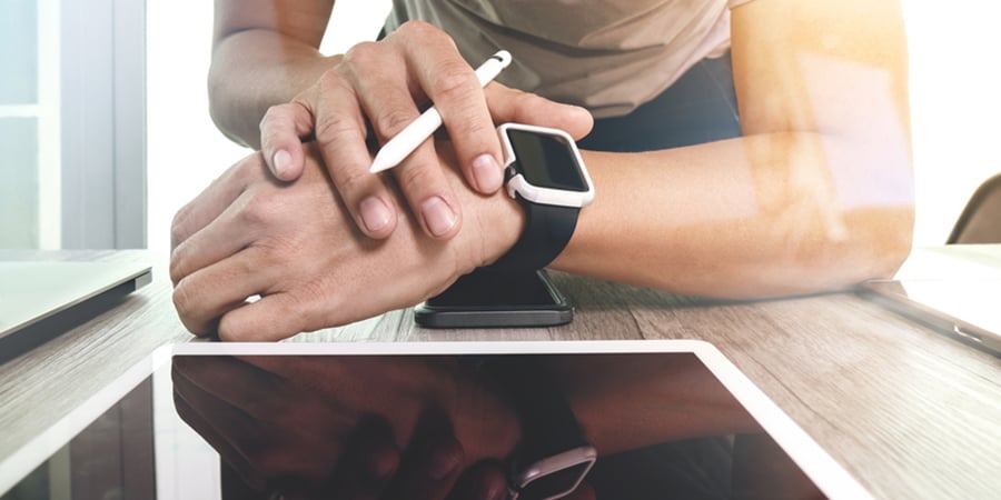 man using smart watch and tablet