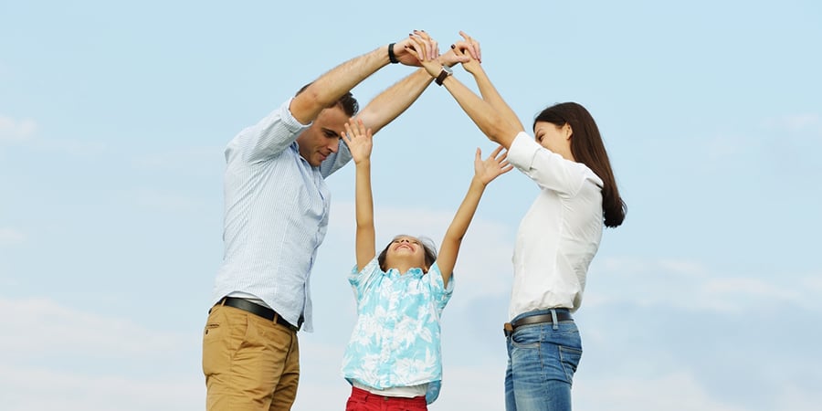 Young family on green summer grass meadow building dream new home