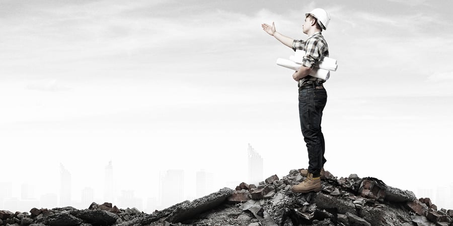 Young man builder looking thoughtfully at construction project. Idea concept