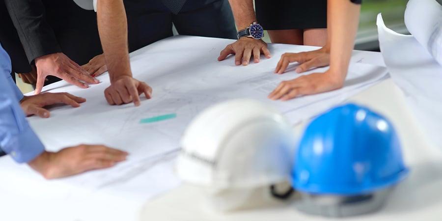 business people group on meeting and presentation  in bright modern office with construction engineer architect and worker looking building model and blueprint  plans