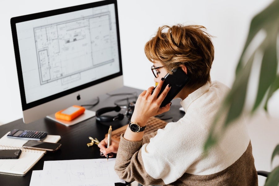 Businesswoman on phone in front of computer
