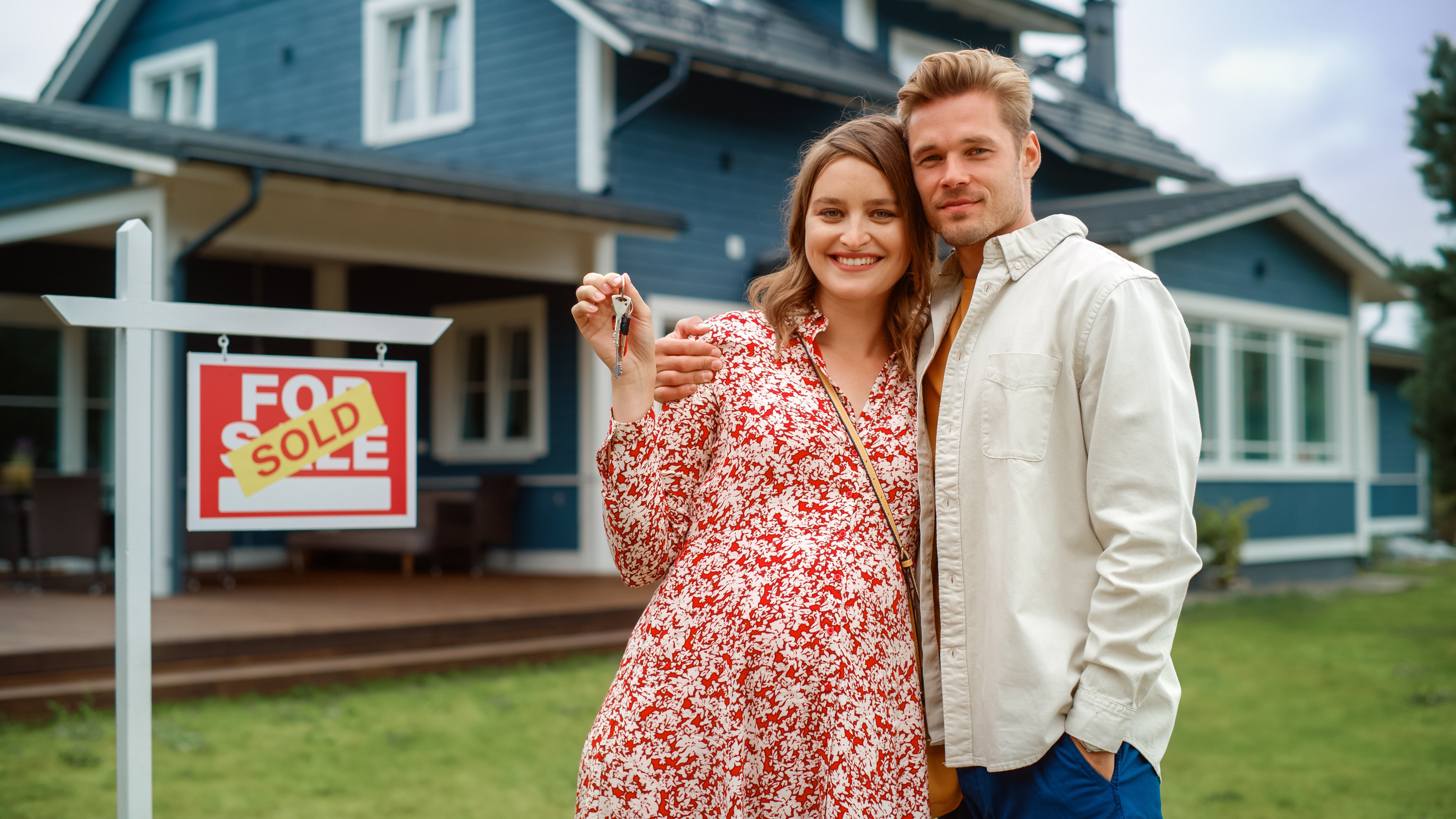 Couple standing in front of a house they just purchased
